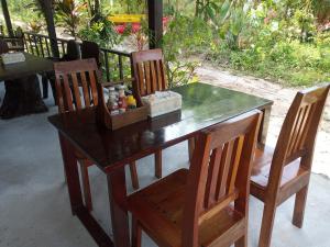 a wooden table with two chairs and a table with spices at Bangkaew Camping place bangalow in Krabi town
