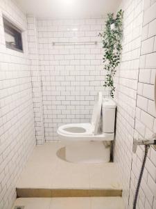 ハジャイにあるGarmin House 8PAX 3BR in Hatyai Townの白いバスルーム(植物のあるトイレ付)