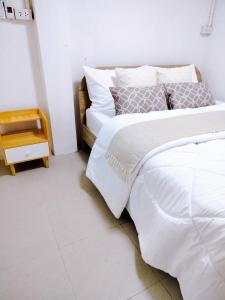 a bedroom with a large bed with white sheets at Gamin house hatyai city in Ban Khlong Toei (1)
