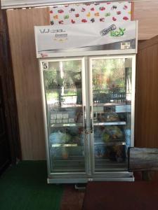 una nevera con la puerta abierta con comida dentro en Bangkaew Camping place bangalow, en Krabi
