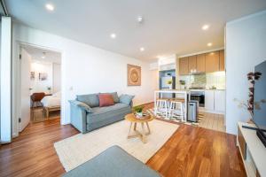a living room with a couch and a table at Wattle on Morphett - Central CBD Convenience in Adelaide