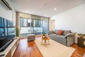 a living room with a couch and a table at Wattle on Morphett - Central CBD WiFi in Adelaide
