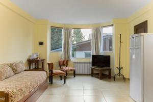 - un salon avec un canapé et une télévision dans l'établissement Rivendell Bungalows Bariloche, à San Carlos de Bariloche