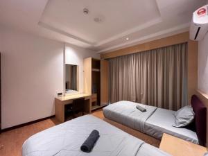 a hotel room with two beds and a desk at Nick's Homestay @Boulevard mall @ Imperial Suites in Kuching +69 photos