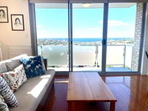 a living room with a couch and a table at Perfect Randwick Escape -2Bdrm-Parking - Walk To Hospital & Shops in Sydney