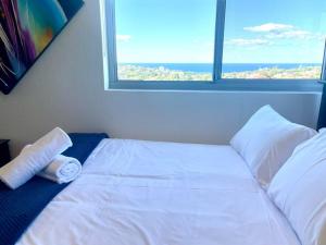 a white bed in a room with a window at Perfect Randwick Escape -2Bdrm-Parking - Walk To Hospital & Shops in Sydney