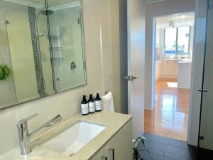 a bathroom with a sink and a glass shower at Perfect Randwick Escape -2Bdrm-Parking - Walk To Hospital & Shops in Sydney