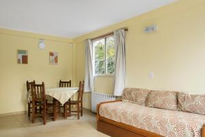 - un salon avec un canapé, une table et une fenêtre dans l'établissement Rivendell Bungalows Bariloche, à San Carlos de Bariloche