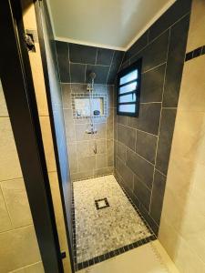 a bathroom with a shower with a tiled floor at STUDIO Le vent qui chuchote in Saint-Benoît