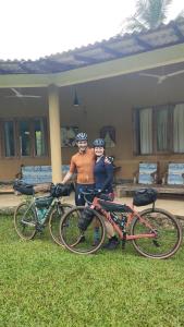 Ein Mann und eine Frau stehen neben zwei Fahrrädern. in der Unterkunft Rivendell Twisted Tree in Kurunegala
