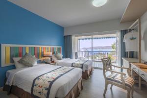a hotel room with two beds and a balcony at Somewhere Koh Sichang in Ko Si Chang