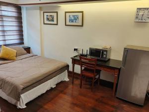 a bedroom with a bed and a desk with a microwave at Port Dickson Teluk Kemang Pantai Tanjung Gemok by 3SIBS in Port Dickson