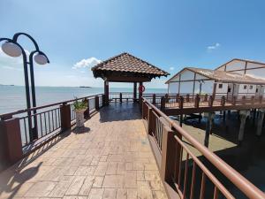a pier next to the water with a street light at Port Dickson Teluk Kemang Pantai Tanjung Gemok by 3SIBS in Port Dickson