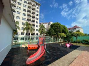a playground with a slide in front of a building at Port Dickson Teluk Kemang Pantai Tanjung Gemok by 3SIBS in Port Dickson