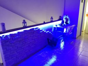 um quarto com uma parede de tijolos com luzes azuis em Casa vacanza Contry House Romantic em Grammichele