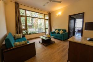 a living room with two chairs and a couch at Kasauli Castle Resort in Kasauli