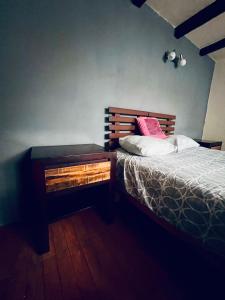 a bedroom with a bed and a nightstand next to it at Casa Buganbilia in San Sebastián Etla