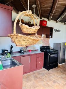 una cocina con una cesta colgada sobre un fregadero en Casa Buganbilia en San Sebastián Etla