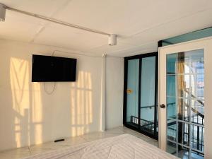 a bedroom with a flat screen tv on a wall at Chubby 9 in Bang O