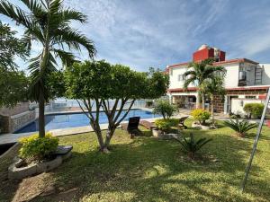 a resort yard with a swimming pool and a building at Terraza del Lago in Tequesquitengo