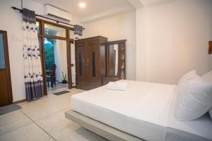 - une chambre avec un grand lit blanc dans l'établissement D2 Villa Unawatuna, à Galle