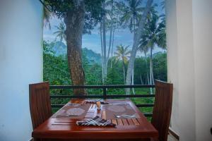 a wooden table with a view of a forest at D2 Villa Unawatuna in Galle