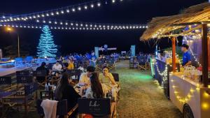 Blu Hotel في ناخون فانوم: مجموعة من الناس يجلسون على الطاولات في حفلة عيد الميلاد