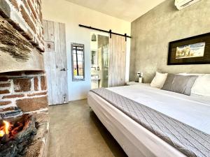 a bedroom with a bed next to a fireplace at Baja House in Todos Santos +48 photos