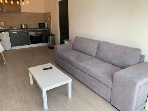 a living room with a couch and a table at bellucciu di porto vecchio***. (Piscine chauffée) in Porto-Vecchio +4 photos