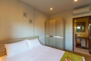 a bedroom with a white bed and a wooden cabinet at Autumn Condo in Hua Hin +16 photos