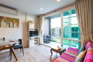 a living room with a couch and a table at Autumn Condo in Hua Hin