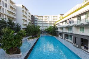 a swimming pool in the middle of two apartment buildings at Autumn Condo in Hua Hin