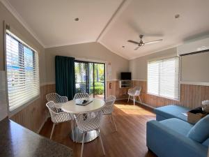 a living room with a blue couch and a table at BIG4 Mackay Blacks Beach Holiday Park in Mackay