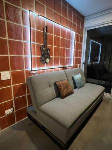a couch in a room with a brick wall at Pura Vida Hub - Iconnia in San José