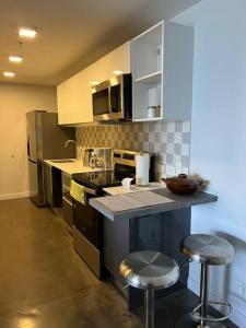 a kitchen with a counter and two stools in it at Pura Vida Hub - Iconnia in San José
