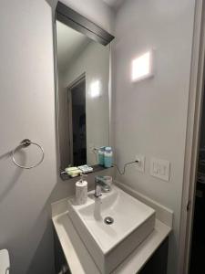 a white bathroom with a sink and a mirror at Pura Vida Hub - Iconnia in San José
