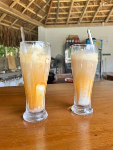 zwei Gläser Getränke auf einem Holztisch in der Unterkunft Shiva Sunrise Resort in Hikkaduwa