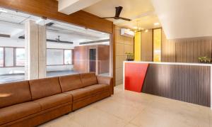 a living room with a brown couch and a counter at Treebo Trend Nestlay Rooms Gummidipoondi in Chennai