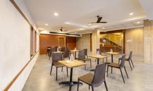 a row of tables and chairs in a restaurant at Treebo Trend Nestlay Rooms Gummidipoondi in Chennai