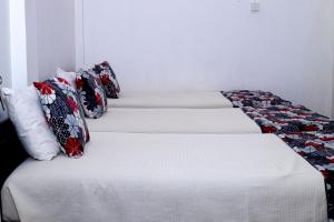 eine Reihe von Betten in einem Zimmer in der Unterkunft Sanasuma Hotel in Hambantota