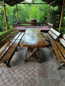 a wooden picnic table with two benches under an umbrella at Yongogsoy Village in Kyzyldzhar