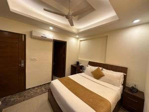 1 dormitorio con 1 cama y ventilador de techo en HOTEL BLUE ORCHID - A 3 STAR HEAVEN IN Tricity, en Zirakpur