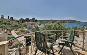 two chairs sitting on a balcony overlooking the water at Apartment Milan - 10 m from the sea in Drvenik Veli
