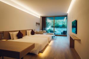 a hotel room with two beds and a large window at MUNI KYOTO by Onko Chishin in Kyoto