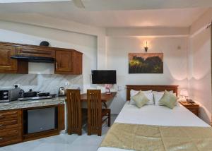 a bedroom with a bed and a kitchen with a desk at Kerawalapitiya Resort in Mahabage