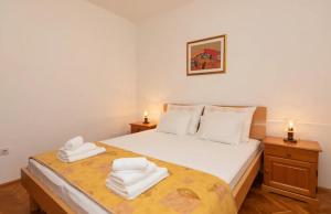 een slaapkamer met een bed met handdoeken erop bij Apartments Stone garden - cosy and comfy in Supetar