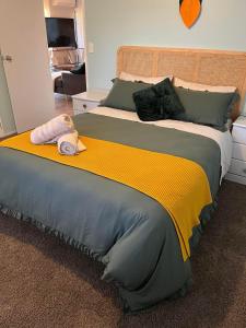 a large bed with a yellow and gray blanket at Cozy corner in Thames