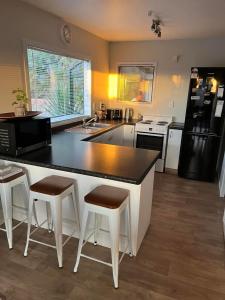 a kitchen with a black and white counter and stools at Cozy corner in Thames