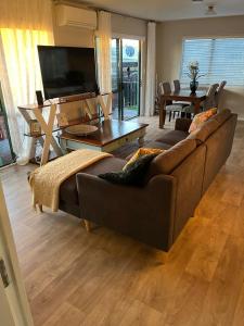sala de estar con sofá marrón y TV en Cozy corner, en Thames