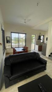 sala de estar con sofá negro y mesa en ECR Ocean Drive Villa with Private Pool, en Chennai